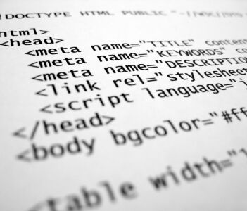 Schlank programmierter HTML5- und CSS3-Quellcode auf einem Monitor für eine performante, SEO-optimierte Unternehmenswebseite.