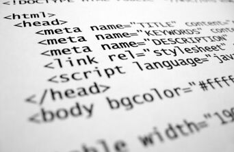 Schlank programmierter HTML5- und CSS3-Quellcode auf einem Monitor für eine performante, SEO-optimierte Unternehmenswebseite.